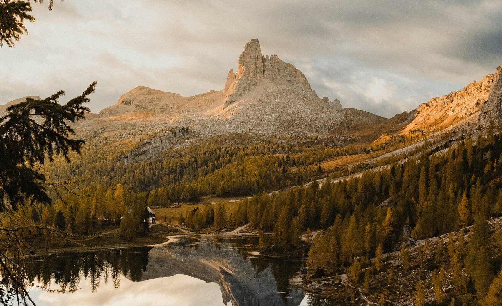 A forest lake reflecting sharp Dolomite peaks