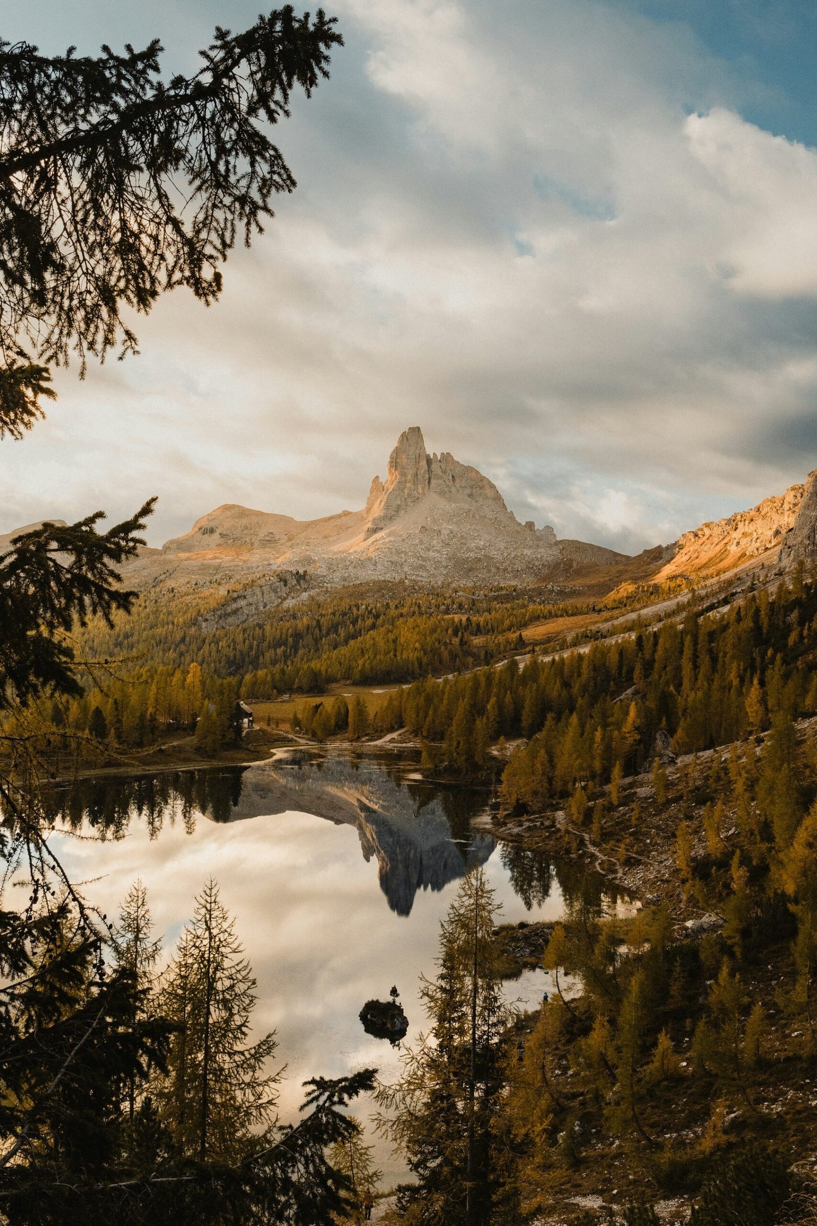 A forest lake reflecting sharp Dolomite peaks