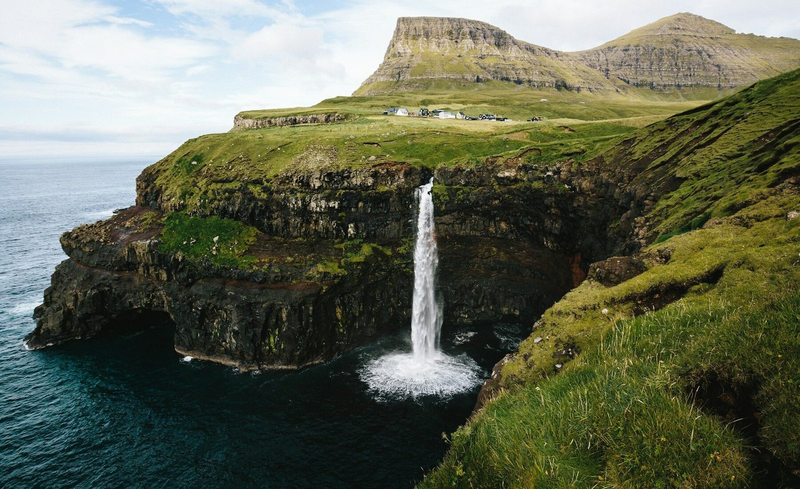 Múlafossur waterfall falling into the ocean in the Faroe Islands