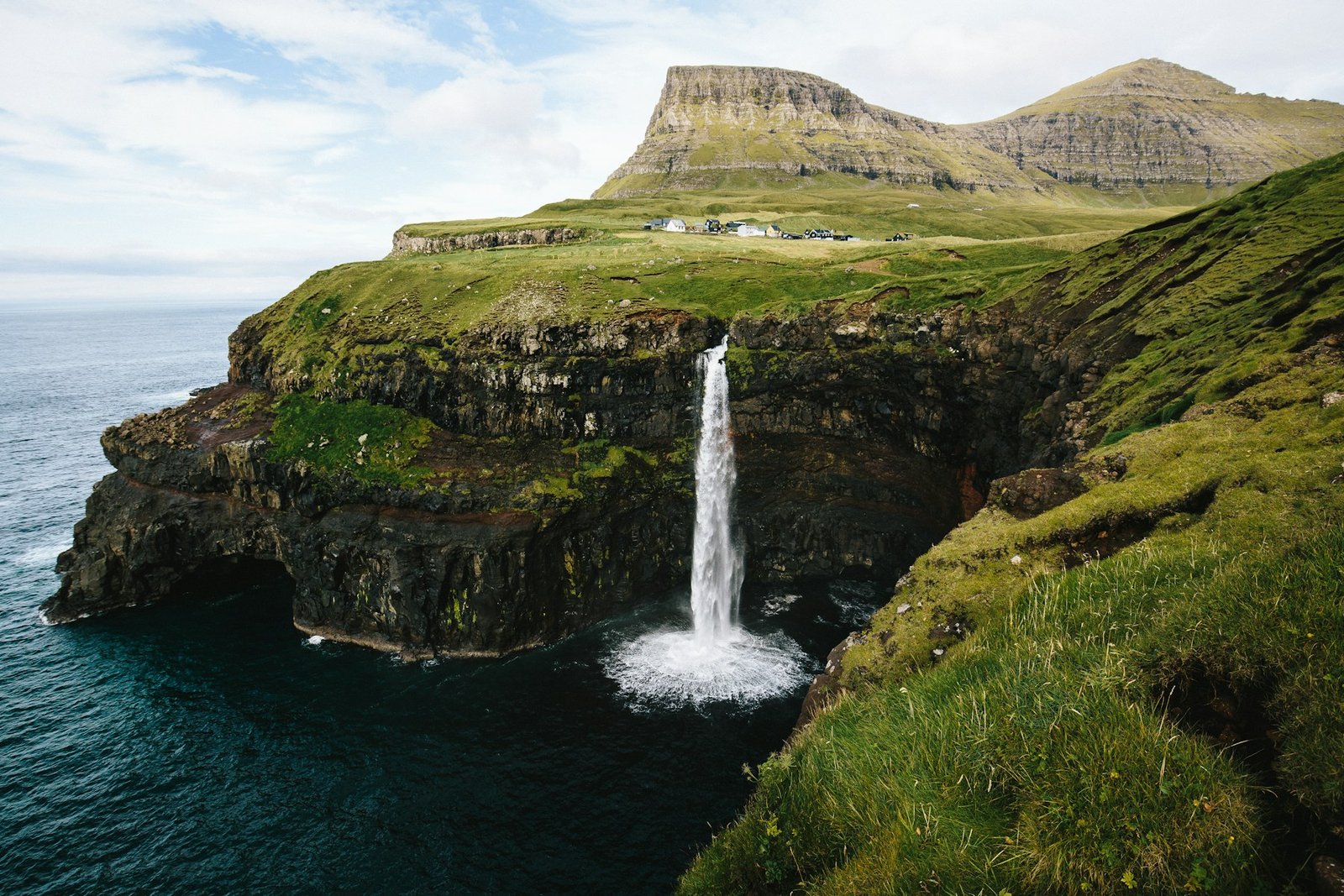 Múlafossur waterfall falling into the ocean in the Faroe Islands