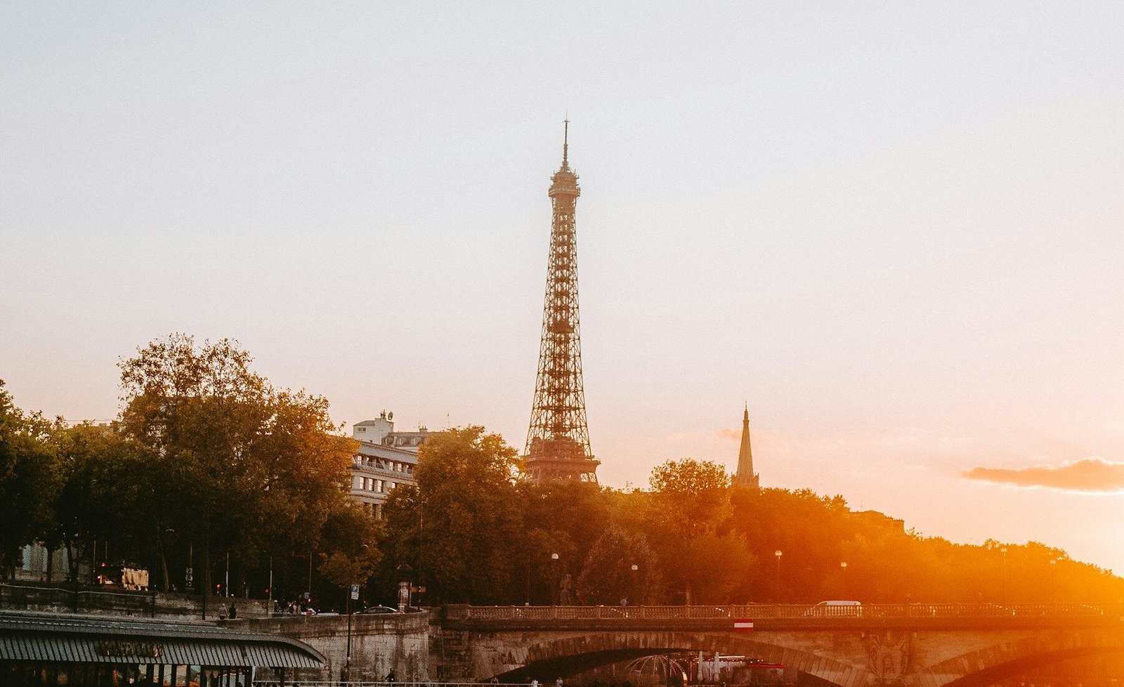The Eiffel Tower and Seine River glowing at sunset
