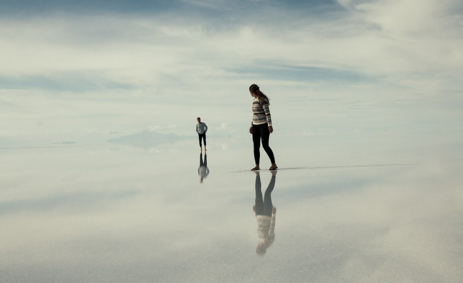 Travelers crossing the reflective Uyuni salt flats