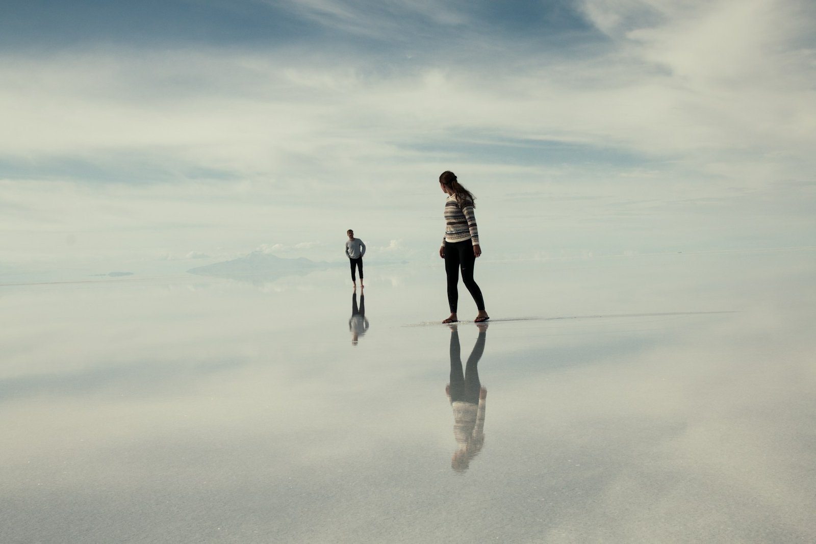 Travelers crossing the reflective Uyuni salt flats