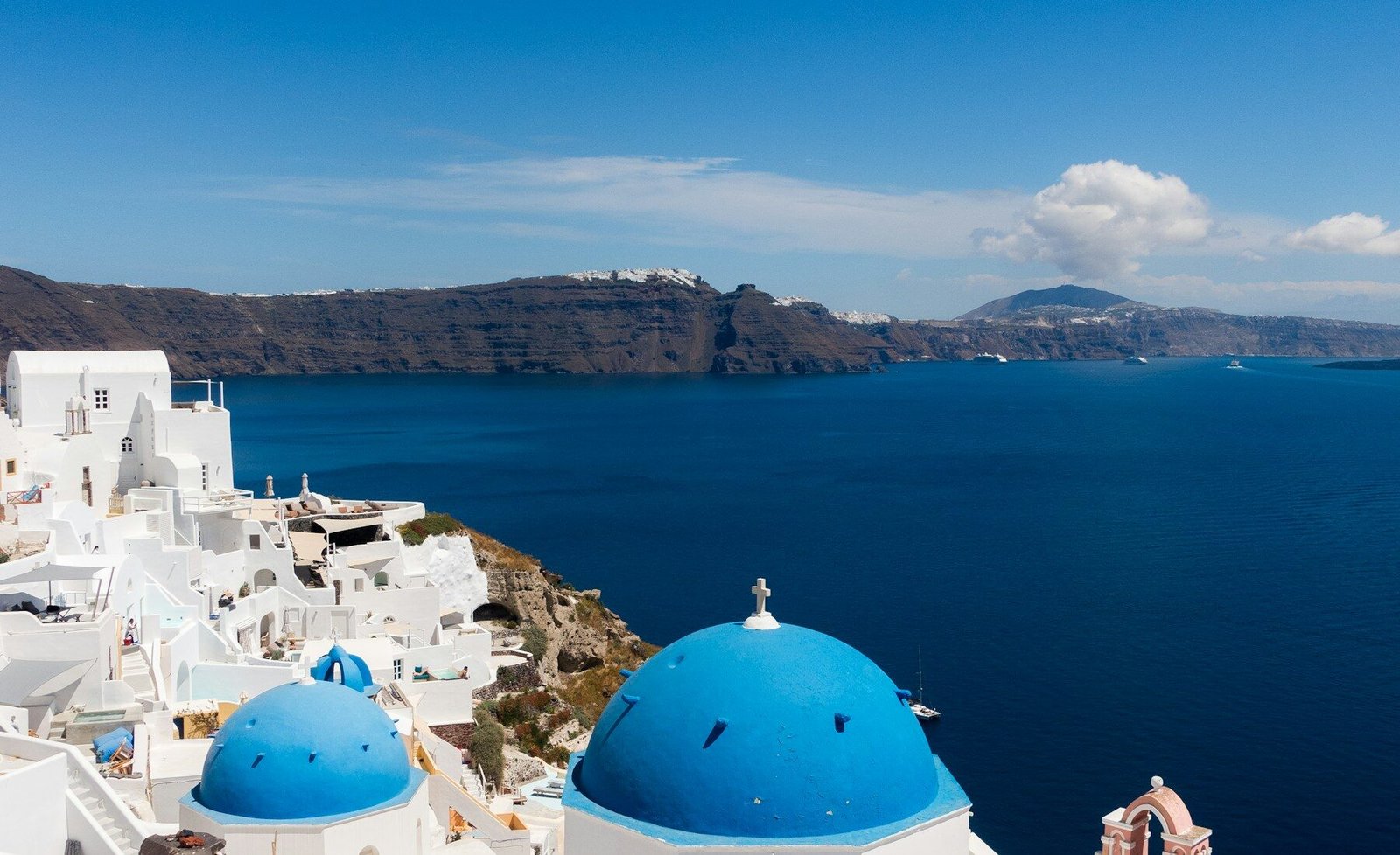 Whitewashed Oia buildings above Santorini’s blue caldera