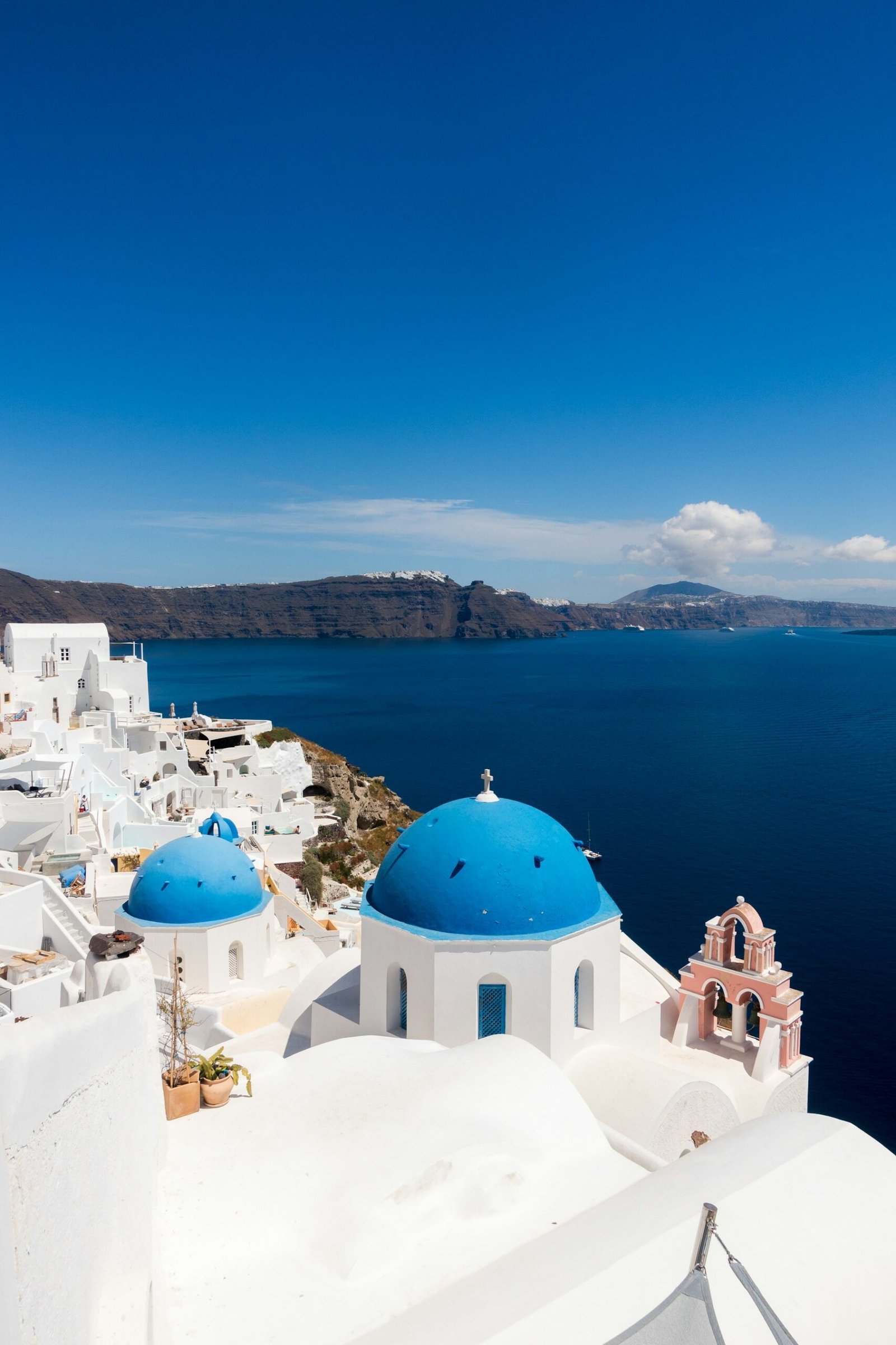 Whitewashed Oia buildings above Santorini’s blue caldera